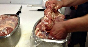 Col·locant les peces de cuixa de porc dins el motlle Col·locant les peces de cuixa de porc dins el motlle