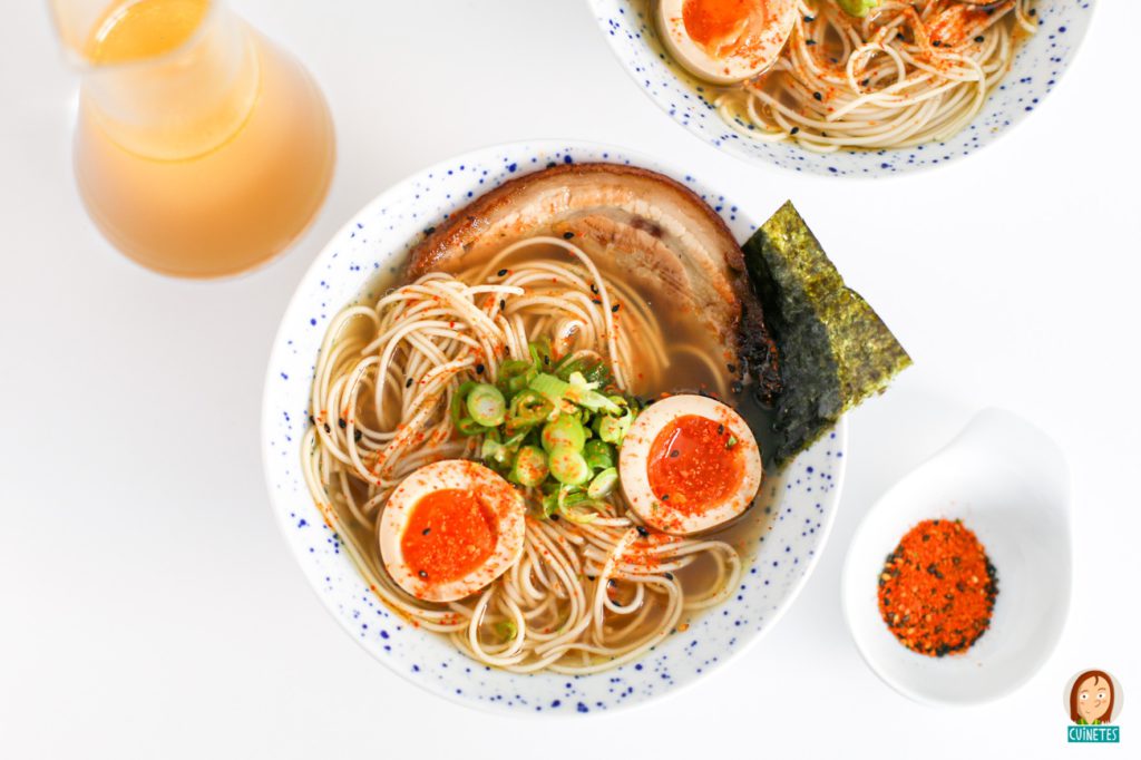 Bol de ramen amb fideus, ou, porc, ceba tendra i alga nori sobre fons blanc
